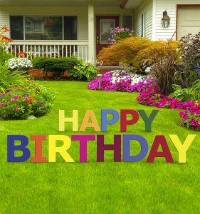 Colorful "Happy Birthday" sign on lawn.