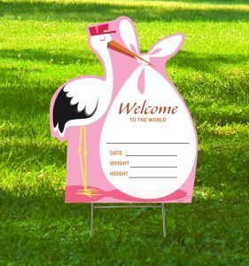 Stork welcome sign on grassy background.