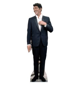 Man in suit smiling with one hand raised.