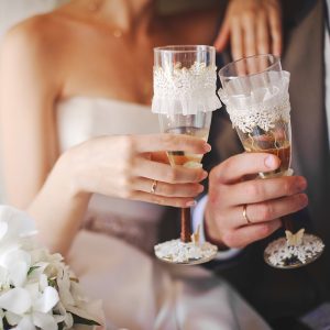 Bride and groom toasting with champagne glasses.