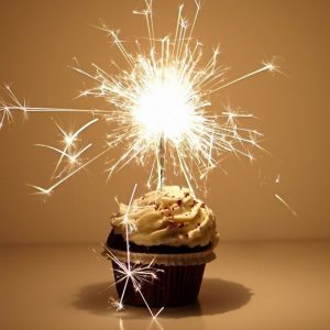 Cupcake with a lit sparkler on top.