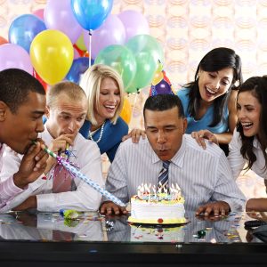 Office birthday celebration with cake and balloons.