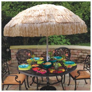 Outdoor table with umbrella and tropical decor.