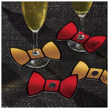 Four stylish bow ties in red and gold colors on a dark textured surface.