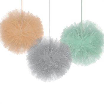 Three fluffy pom-poms in peach, grey, and mint colors hanging by strings.
