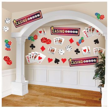 Casino-themed party decorations with cards and dice on a white wall.