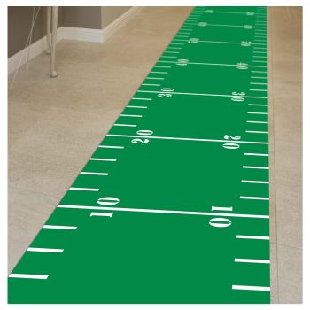 Green indoor turf with football yard markers along a hallway.