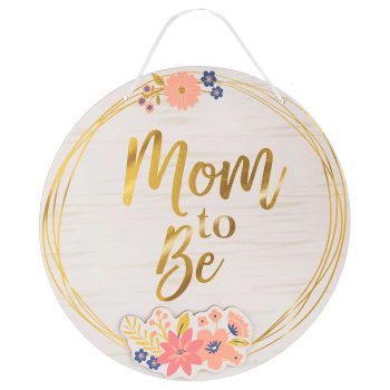 Round sign with 'Mom to Be' and floral decoration.