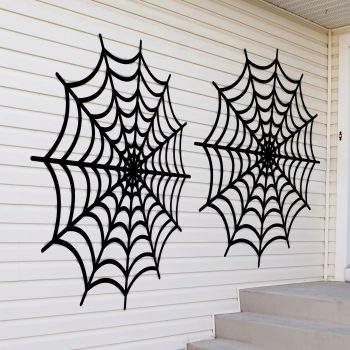 Black spider webs on white house wall.
