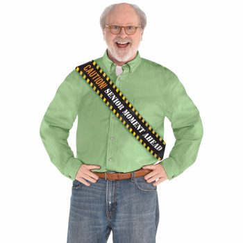 Man wearing "Senior Moment Ahead" sash, smiling.