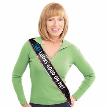 Woman in green sweater with birthday sash.
