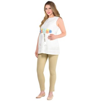 Pregnant woman wearing a white top and beige leggings.