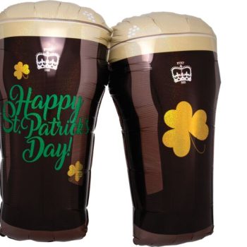 Two pint glasses of dark beer with St. Patrick's Day decorations.