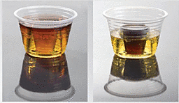 Two plastic cups with different colored liquids on a reflective surface.