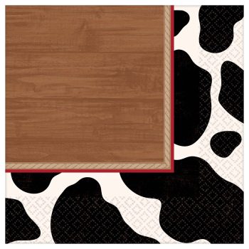 Wooden table corner on a cow print tablecloth.