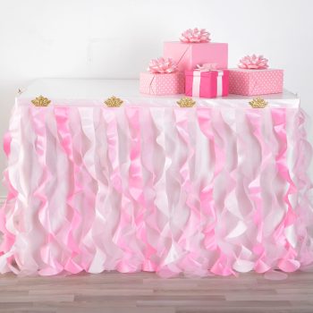 Table with pink ruffled skirt and gifts.