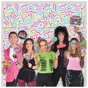 A group of five people in colorful 80s-style outfits posing with fun accessories.