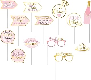 Decorative pink and gold party photo booth props with various phrases and shapes.