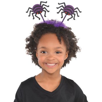 Child wearing spider-themed headband, smiling.