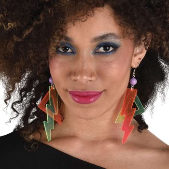 Woman with curly hair wearing colorful lightning bolt earrings and purple eye makeup.