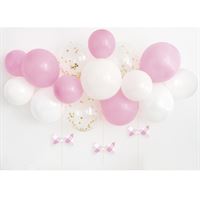 Pink and white balloons arranged with matching bows and confetti.