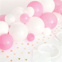 Pink and white balloons with gold confetti on a white surface.