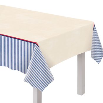 A rectangular table with a cream tablecloth and blue-striped border.